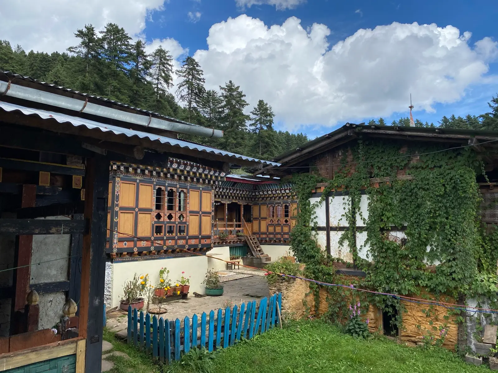 Traditional Bhutanese farmhouse with painted windows and a garden