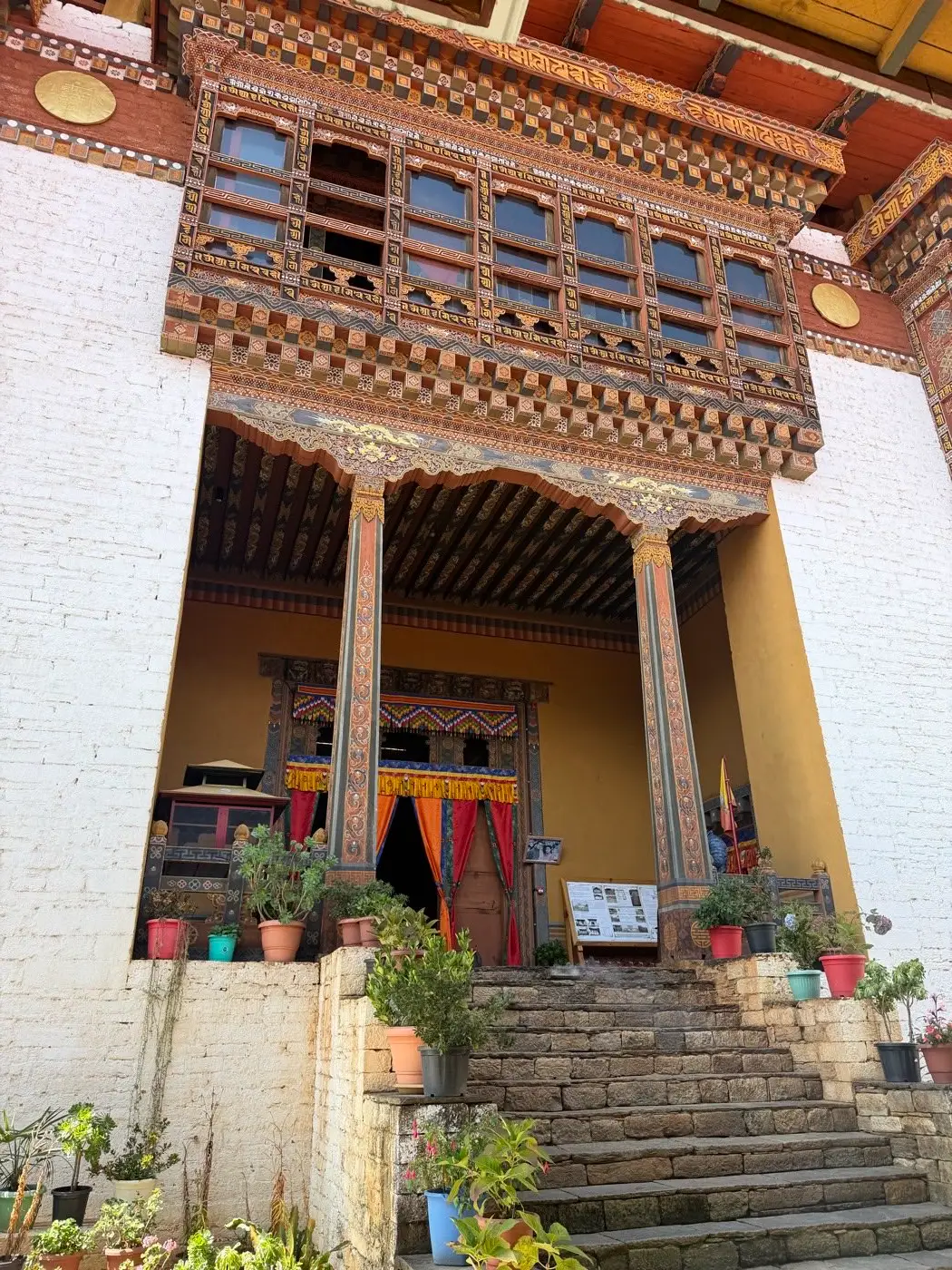 Traditional temple with carved wooden windows and prayer wheels